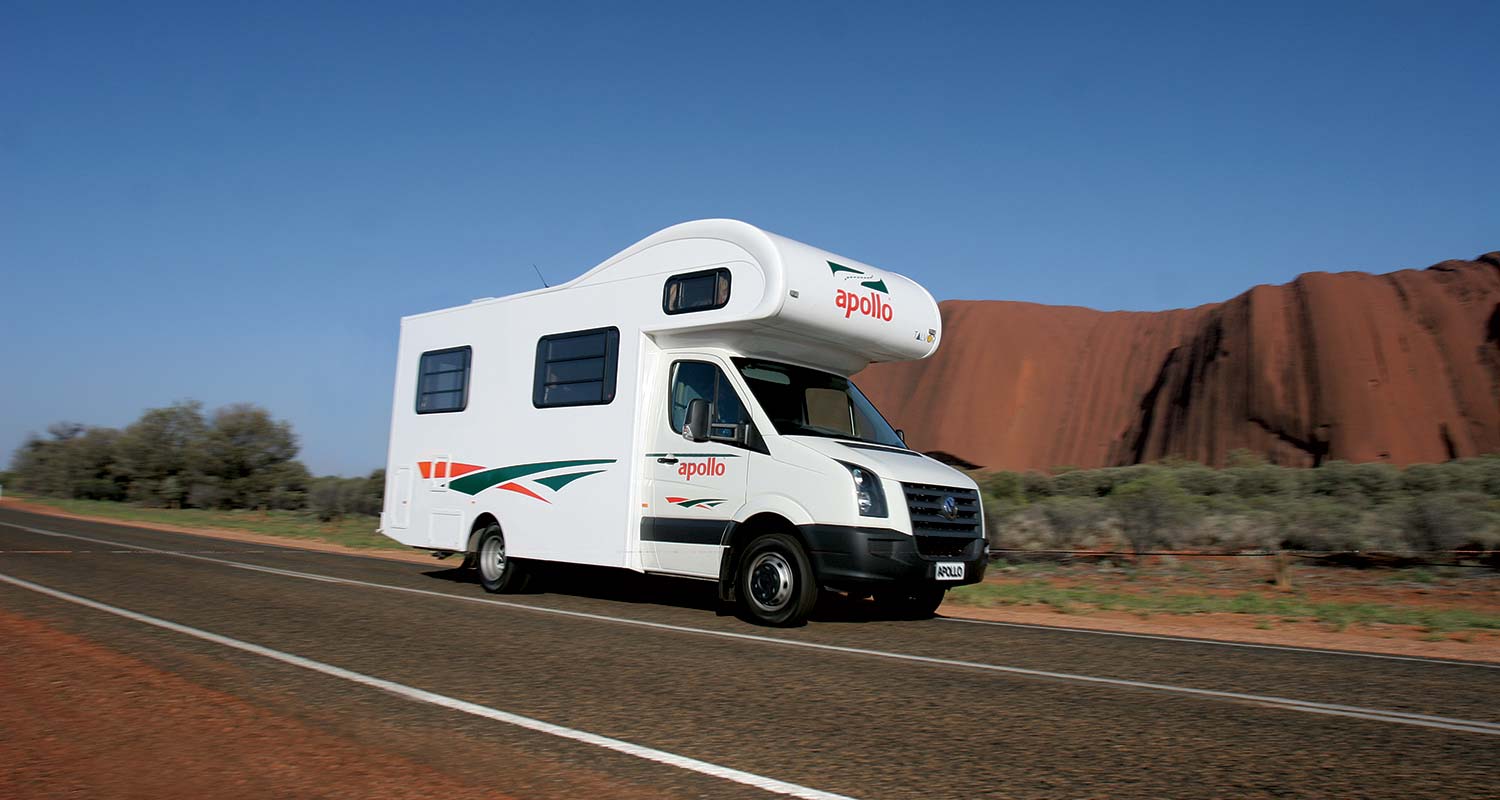 Campervan driving past Uluru