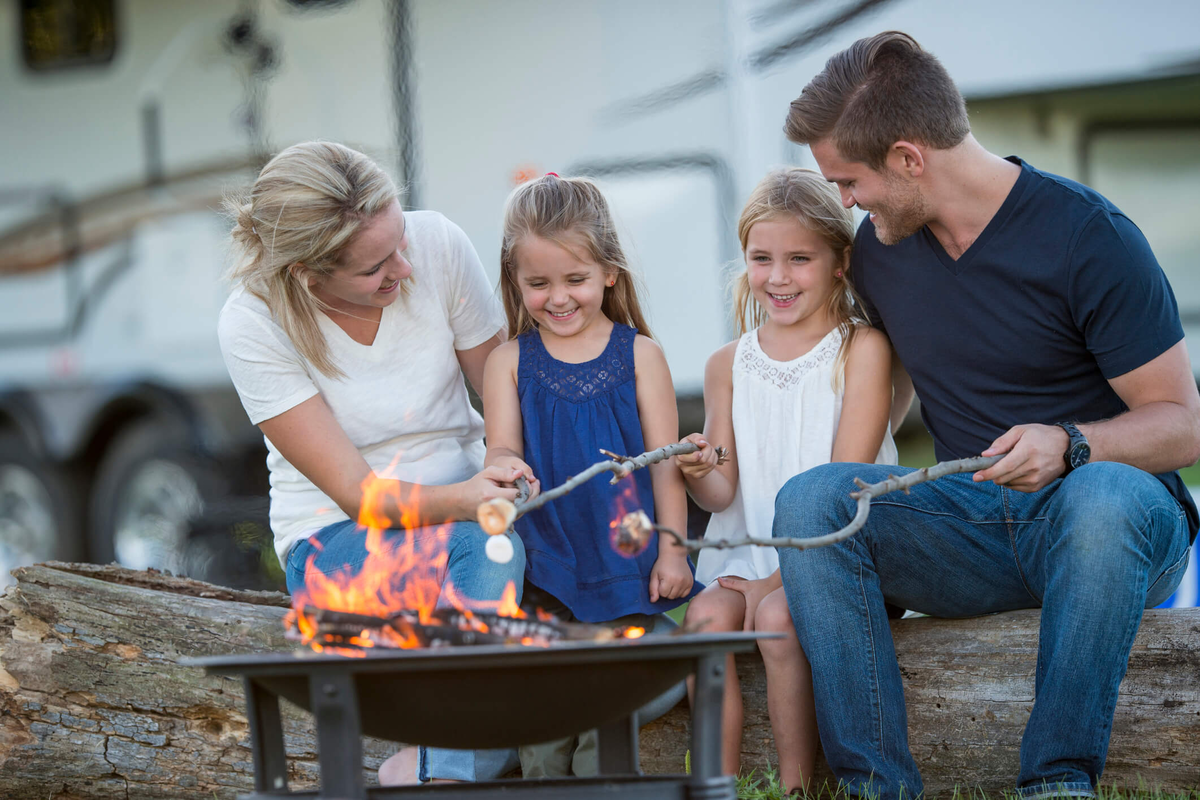 Family with camper and campfire